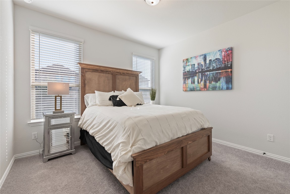 261 Fawn Riv Run Kyle, TX 78640 - Photo 14 of 40 a large bed sitting in a bedroom next to a window