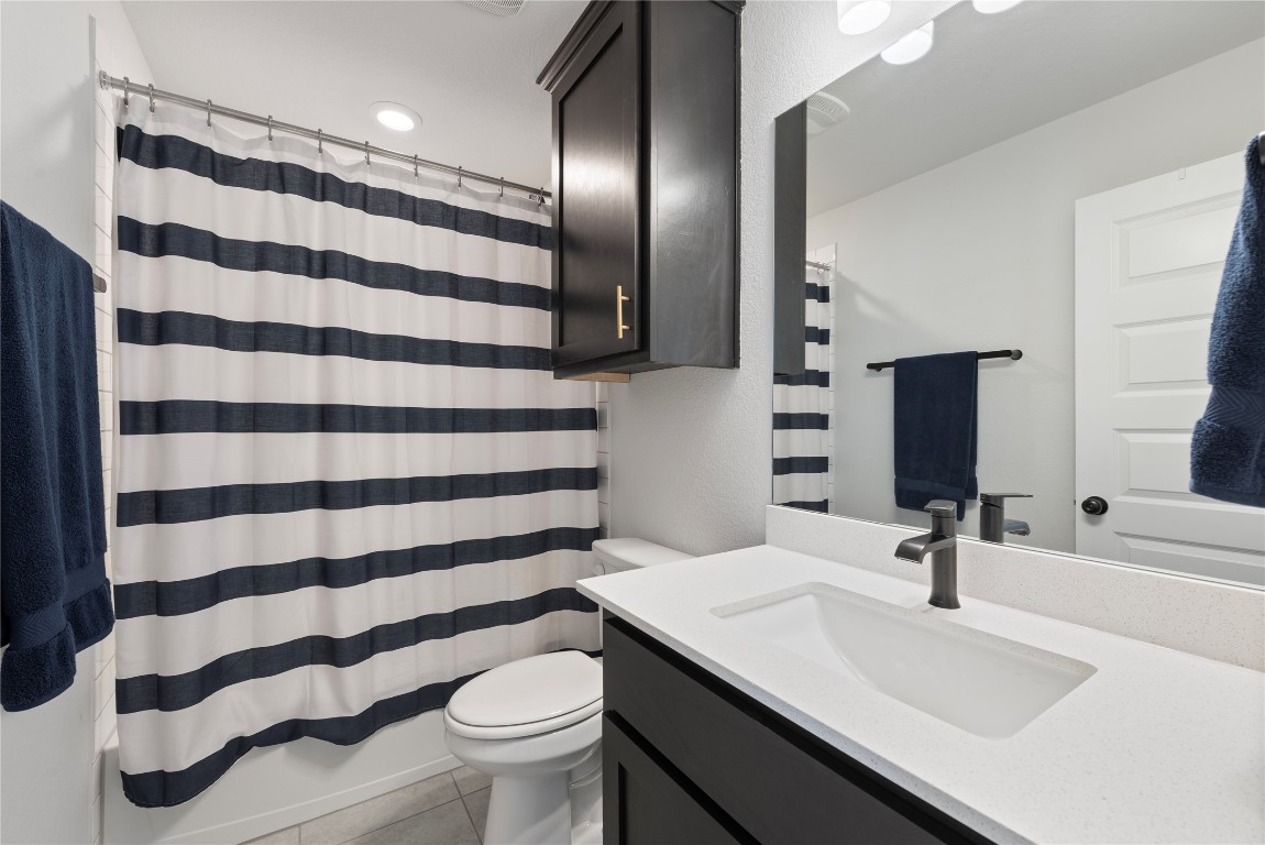 261 Fawn Riv Run Kyle, TX 78640 - Photo 25 of 40 a bathroom with a sink a toilet a large mirror and shower curtain
