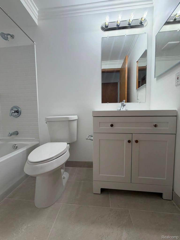 Bathroom featuring a white vanity with integrated sink, chrome faucet, and rectangular mirror