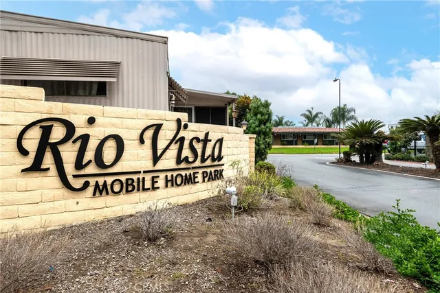 a view of a house with potted plants and a large tree