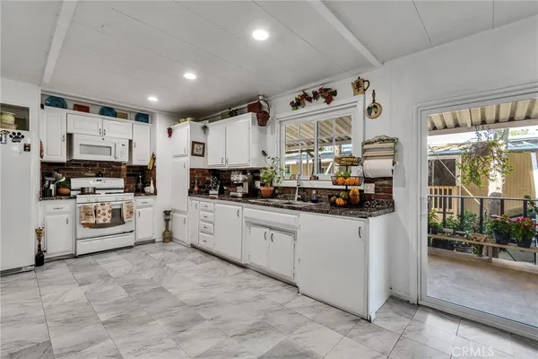 a kitchen with stainless steel appliances a refrigerator sink and microwave