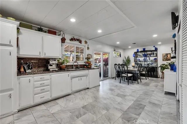 a kitchen with lots of chairs a sink a counter and appliances