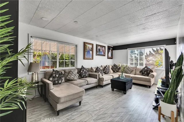 a living room with furniture and floor to ceiling windows