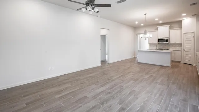 a large kitchen with a wooden floor and stainless steel appliances