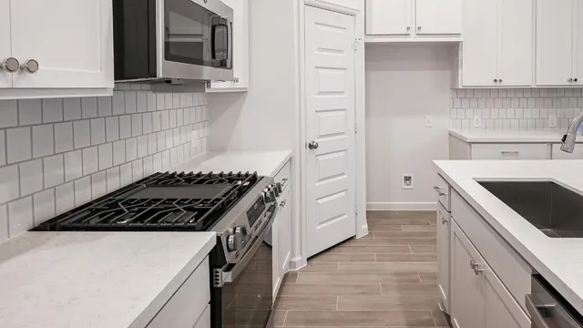 a kitchen with granite countertop a sink stove and cabinets