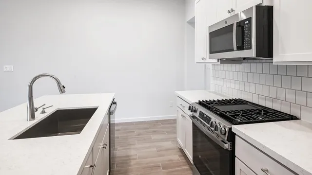 a kitchen with granite countertop a stove and a sink