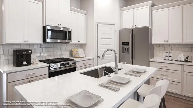 a kitchen with stainless steel appliances a stove a sink a microwave a refrigerator and cabinets