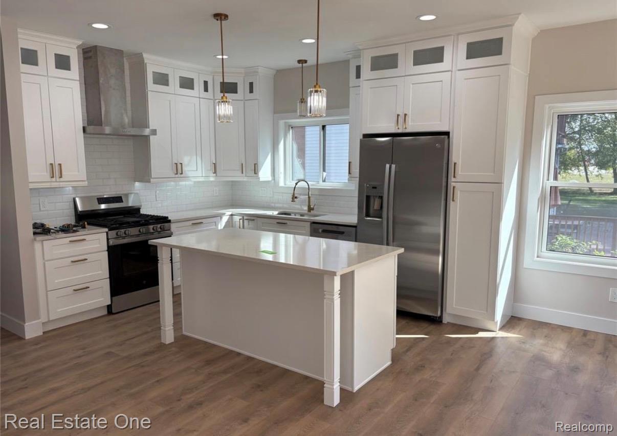 5636 Paris Street Sterling Heights, MI 48310 - Photo 8 of 37 Kitchen featuring stainless steel appliances, glass insert cabinets, white cabinetry, and decorative light fixtures