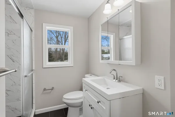 a bathroom with a toilet sink and mirror