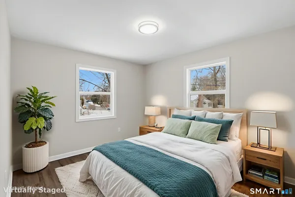 a bedroom with a bed and a potted plant