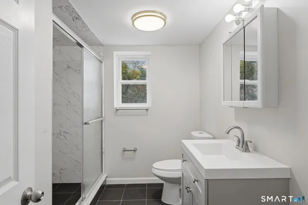a bathroom with a sink toilet and mirror