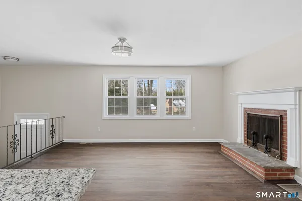 an empty room with a fireplace and wooden floor