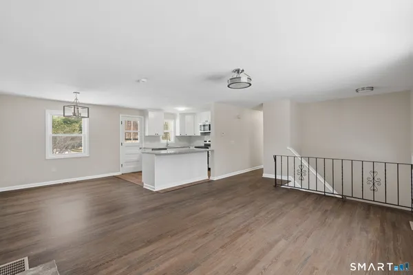 a view of kitchen with wooden floor and electronic appliances