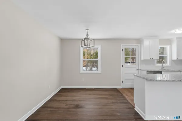 an empty room with kitchen cabinet and wooden floor
