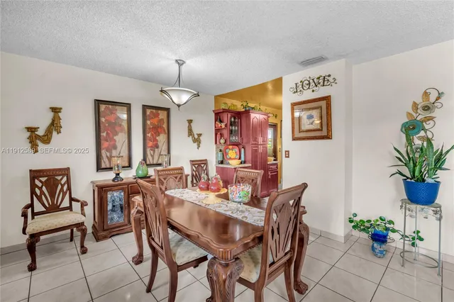 a dining room with furniture potted plants and wooden floor