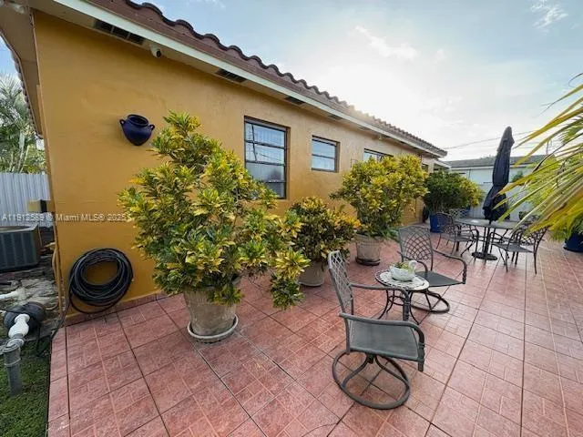 a view of a patio with chairs and potted plants