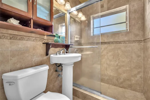 a bathroom with a sink mirror toilet and shower