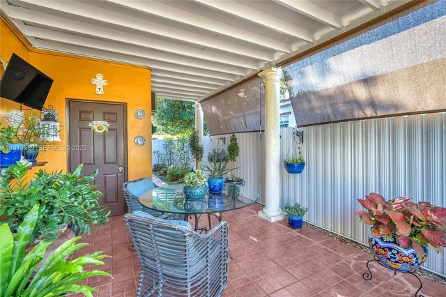 a view of a porch with furniture and floor to ceiling window