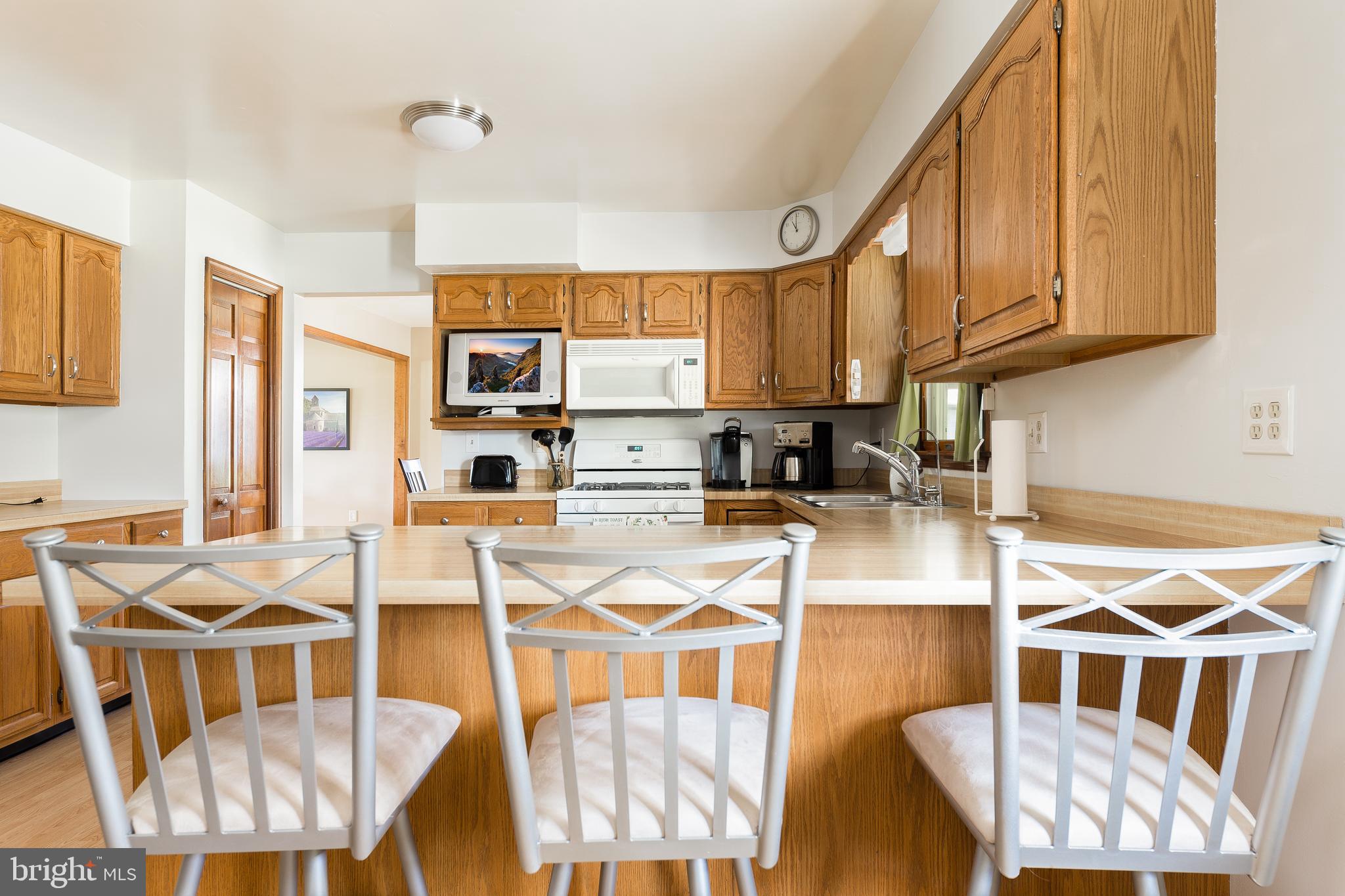 1250 Centerton Road Elmer, NJ 08318 - Photo 7 of 23 a kitchen with stainless steel appliances kitchen island granite countertop a table chairs in it and a wooden floor