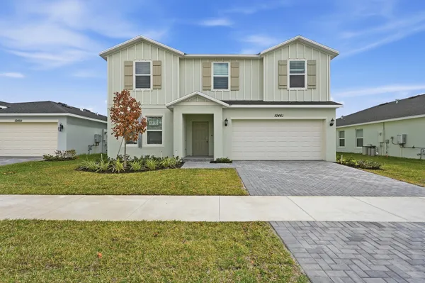 a front view of a house with a yard and garage