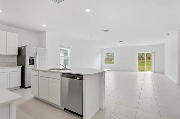 a kitchen with stainless steel appliances granite countertop a sink and a refrigerator