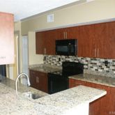 a kitchen with granite countertop a sink and cabinets