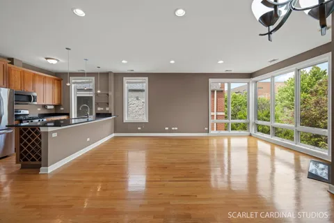 a large kitchen with stainless steel appliances granite countertop a large counter top a stove and a wooden floors
