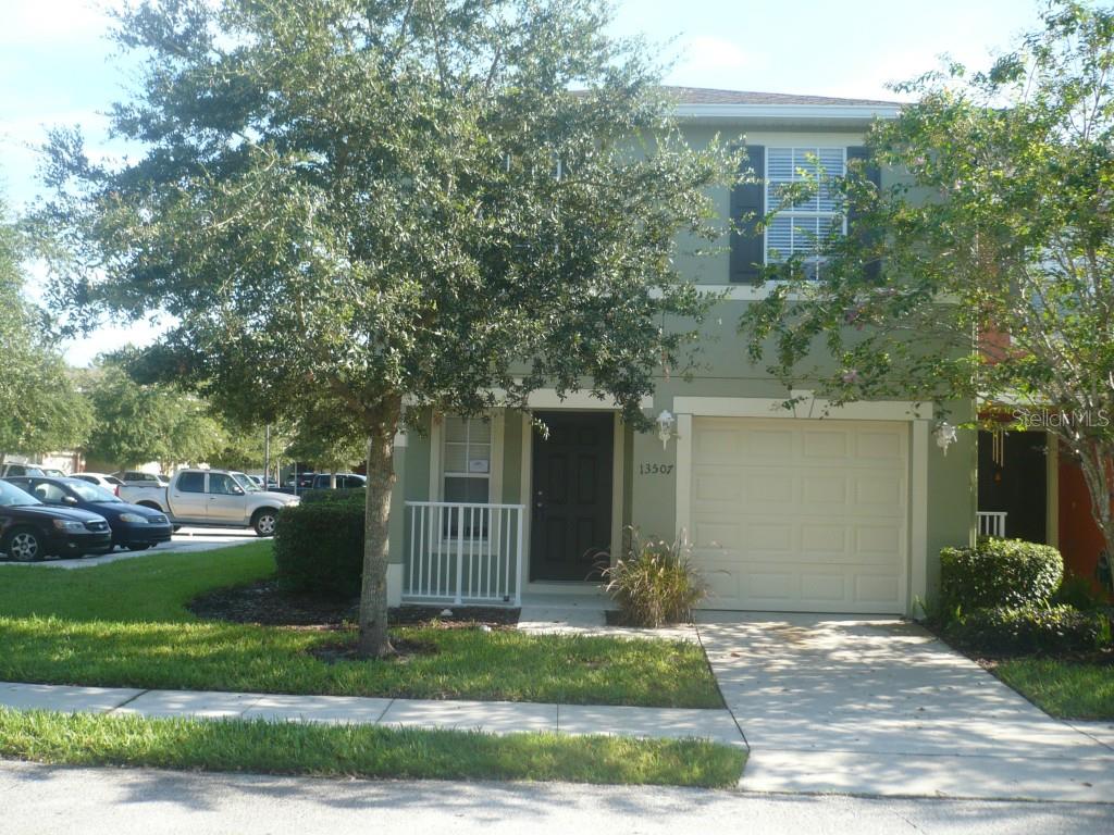 13507 Tea Rose Way, Unit 128 Orlando, FL 32824 - Photo 1 of 1 a front view of a house with a yard