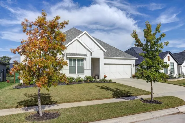 a front view of a house with a yard and tree s
