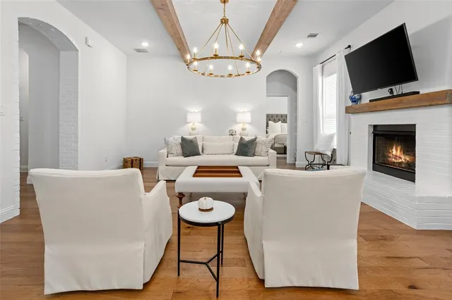 a living room with couches a fireplace and a flat screen tv