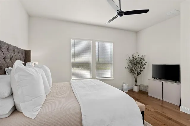 a bedroom with a bed tv and a window