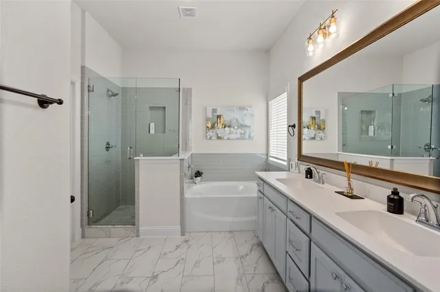 a spacious bathroom with a tub sink a mirror a shower and vanity