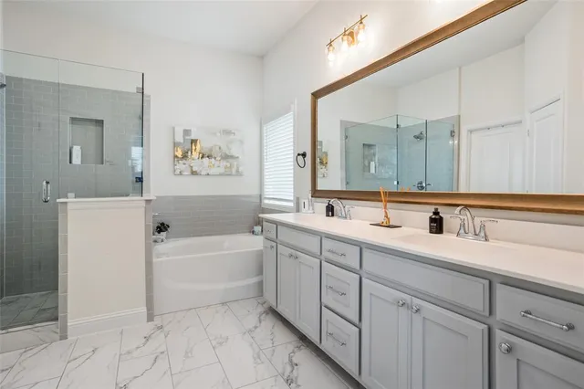 a spacious bathroom with a tub sink and mirror