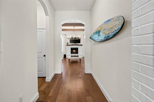 a view of a hallway with wooden floor and a dining room