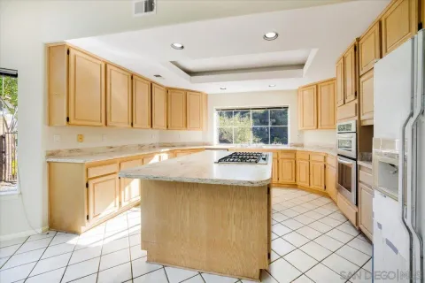 a kitchen with granite countertop a sink a stove and a wooden floor