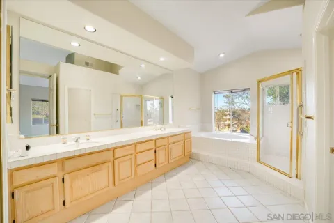 a spacious bathroom with a double vanity sink a mirror and a shower
