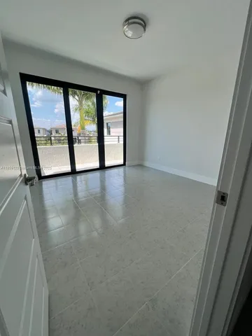 en empty room with windows and ceiling fan