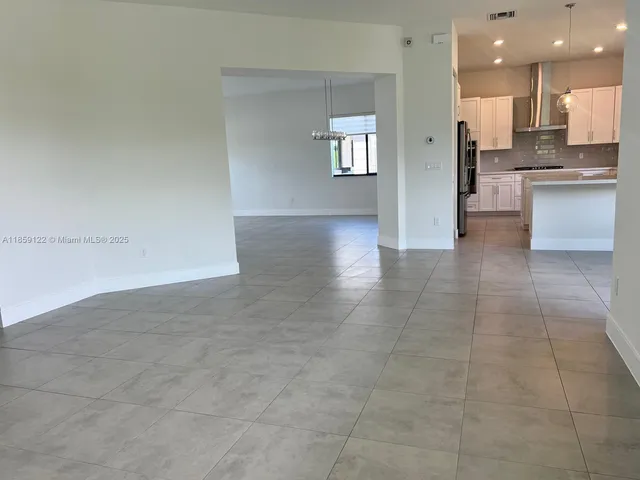 a large kitchen with kitchen island a sink stainless steel appliances and cabinets