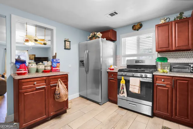 a kitchen with stainless steel appliances granite countertop a refrigerator and a stove