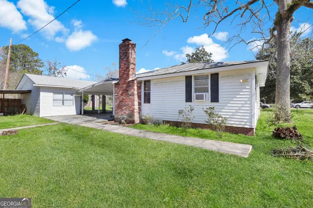 a front view of a house with a garden and yard