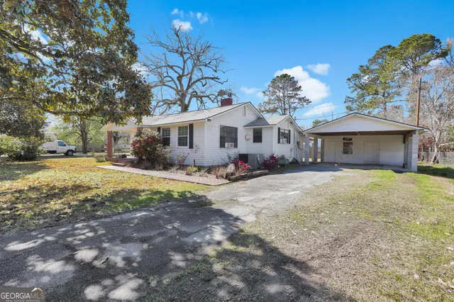 a front view of a house with a yard and trees
