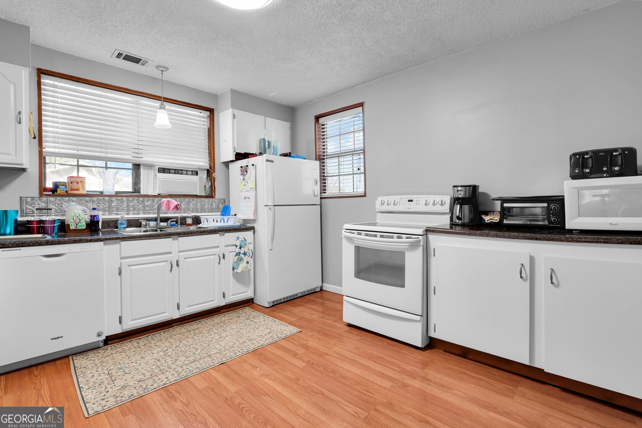 177 Spruce Street Richmond Hill, GA 31324 - Photo 7 of 15 a kitchen with white cabinets and white appliances