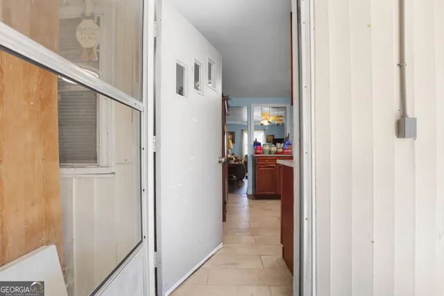 a view of a hallway with wooden floor and a bathroom