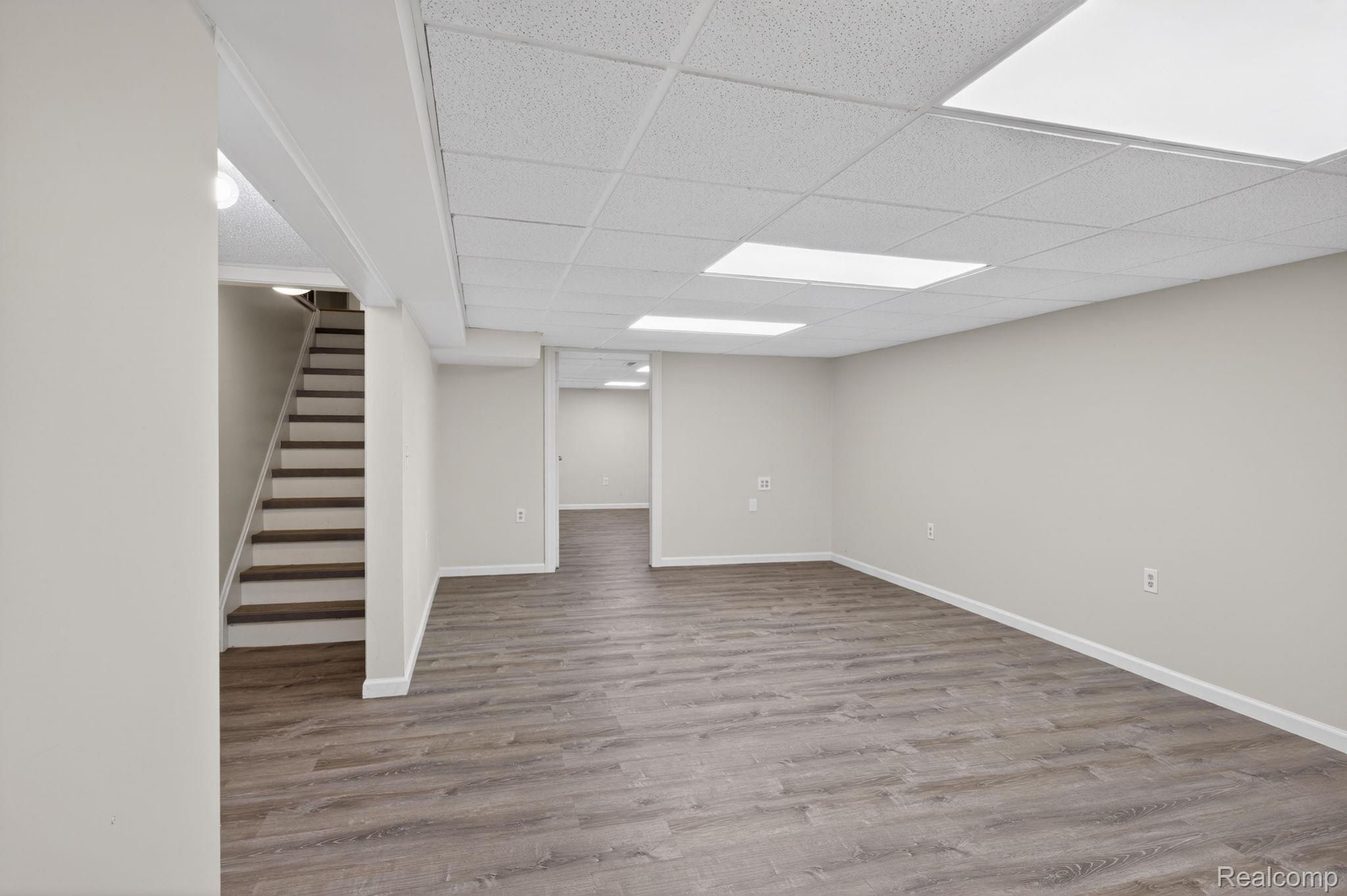 9353 Hill Road Swartz Creek, MI 48473 - Photo 62 of 98 Spacious finished lower level featuring wood-finish flooring, recessed panel lighting, light neutral wall tones, and a drop ceiling