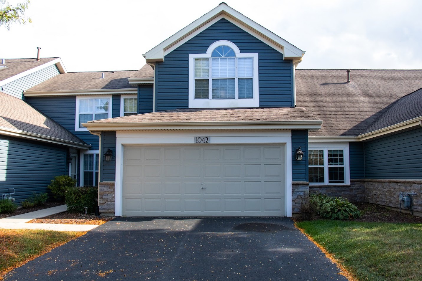 1042 Ridgefield Circle, Unit 1042 Carol Stream, IL 60188 - Photo 1 of 13 a front view of a house with a garden and garage