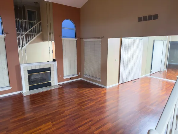 a view of a livingroom with wooden floor and staircase