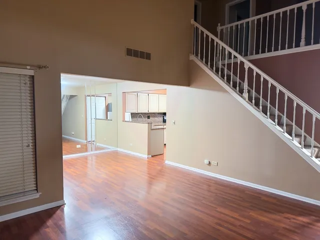 a view of a hallway with wooden floor and staircase
