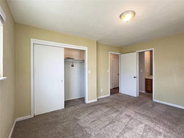 an empty room with closet and a bathroom
