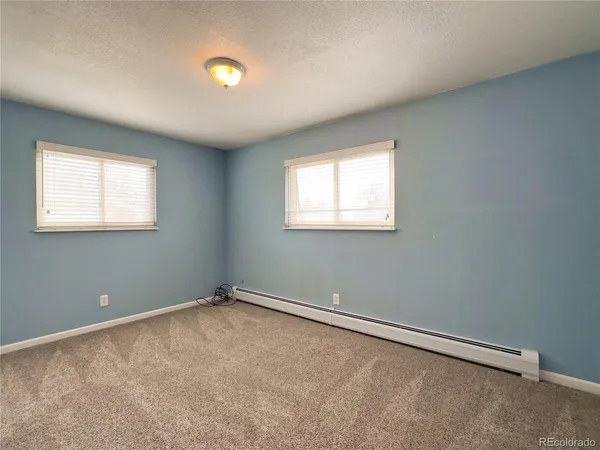 an empty room with windows and closet