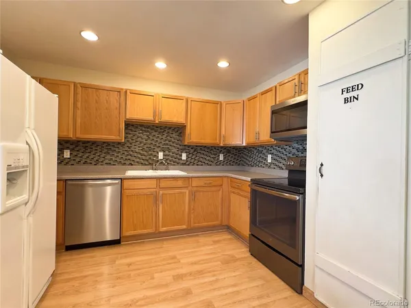 a kitchen with stainless steel appliances granite countertop a refrigerator and a stove top oven